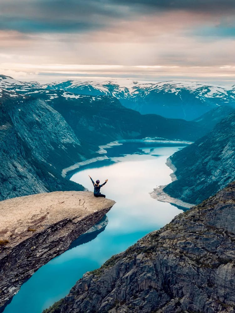 Person Standing On Cliff Overlooking Lake