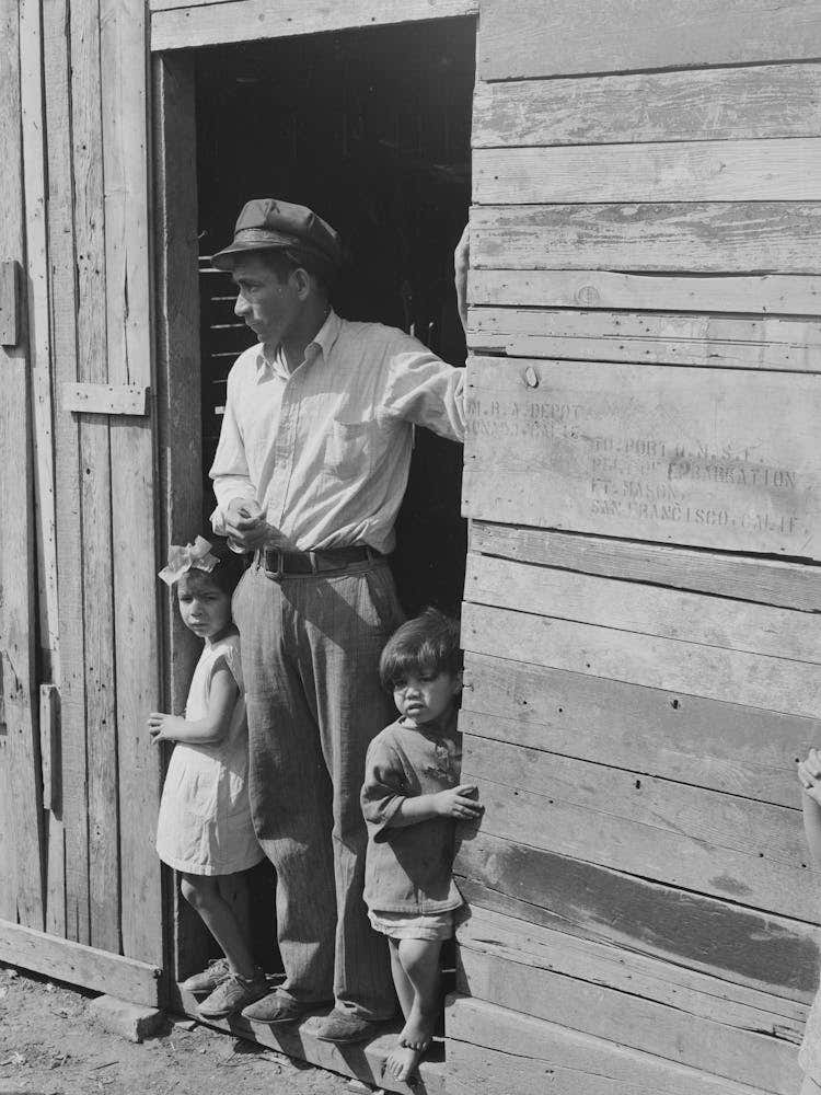 Untitled Photo, Possibly Related To Mexican Father And Children In Doorway Of Their Home Made Of Scrap Lumber