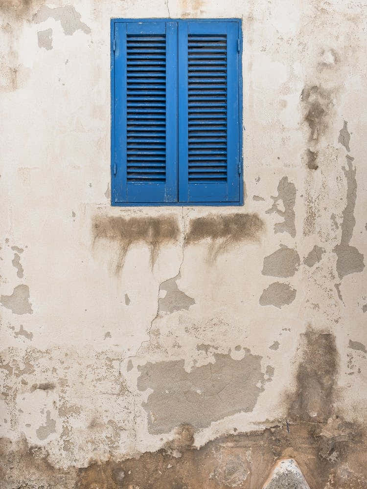 Blue Shutters On An Ancient Wall in Italy