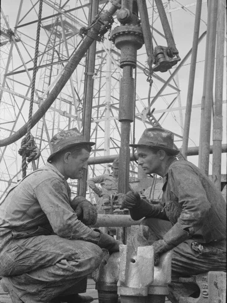 Oil Drillers Talking With Bits In Front Of Them And Drilling Equipment In Background, Kilgore, Texas By Russell