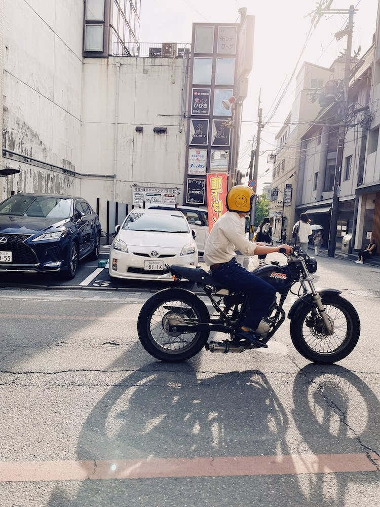 A Man Riding A Motorcycle In A City