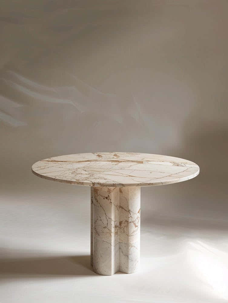 Marble Table, Circular Top With A Small Relief Pattern On The Edge Of The Tabletop, Cream Colored Marble, High End Feel, Minimalist Style, Standing In Front Of It Is An Ailin Meite Logo In The Style Of Product Photography, Front View