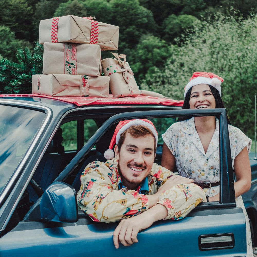 Happy Couple In Car With Presents