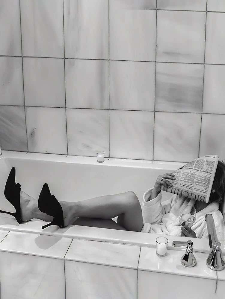 Woman Reading Newspaper In Bathtub