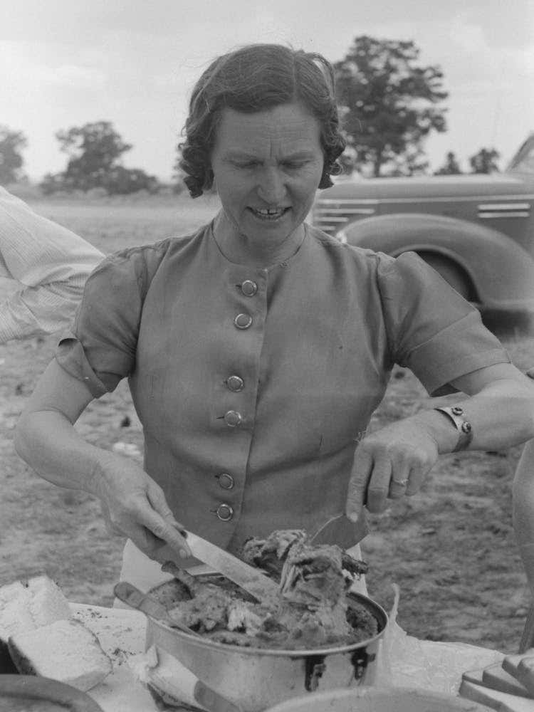 Mrs, Leatherman, Homesteader From West Texas Taking Up Chicken And Dressing At Dinner During The All Day