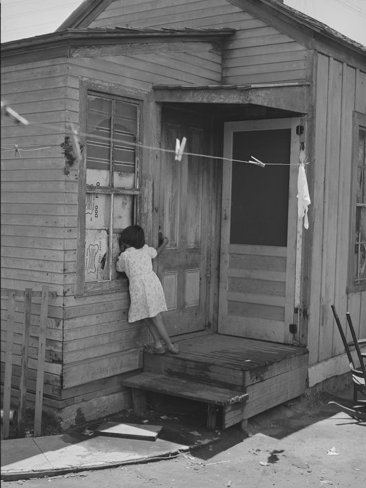 Little Mexican Girl Looking In Window Of Her Home, San Diego, California By Russell Lee