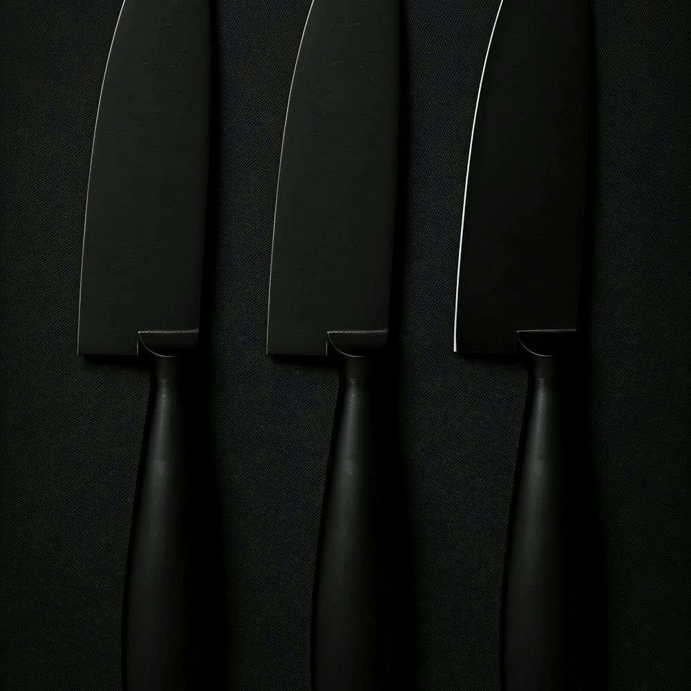 Three Knives On A Black Surface
