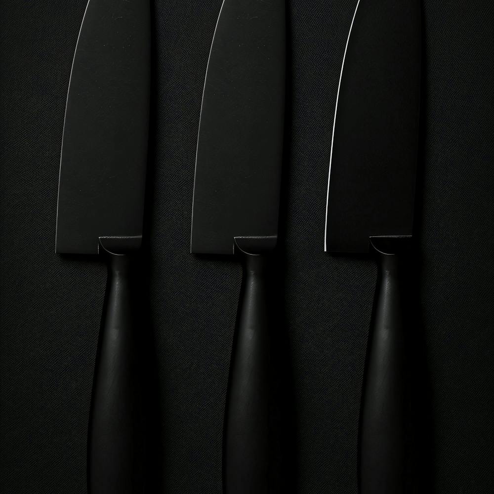 Three Knives On A Black Surface