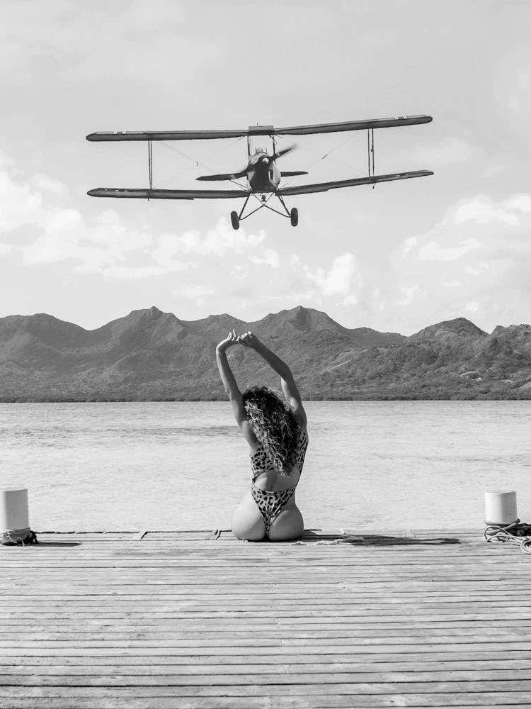 Woman on a Dock - Aircraft Coming In For An Island Landing