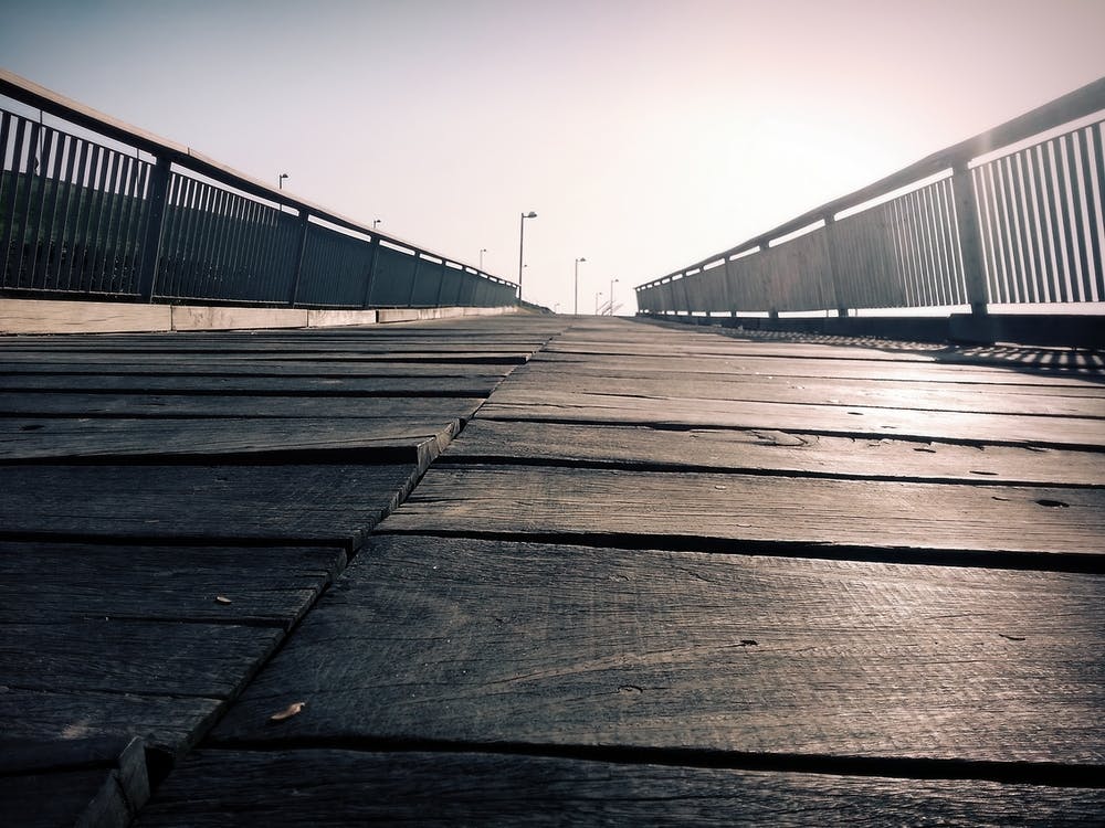 Low angle of a wooden bridge. The horizon seems endless. Sepia colors.