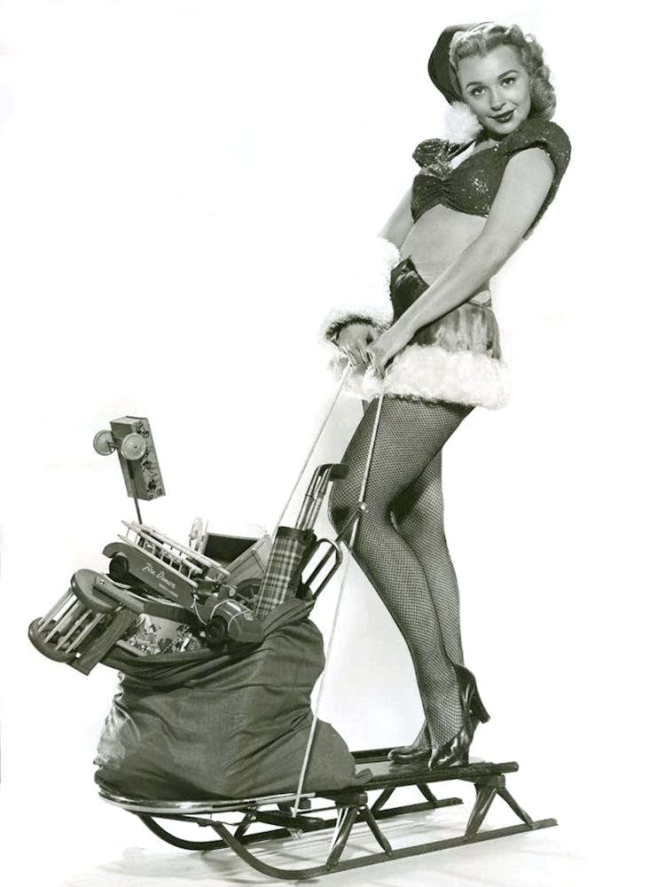 Pinup Girl Posing With Toy Bag On A Sled
