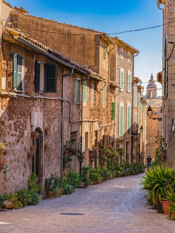 Majorca Spain, plant street in the old village Valldemossa. Explore the historic village of Valldemossa in Majorca, Spain and wander through its charming streets adorned with lush greenery. Admire the rustic architecture and ancient walls, while soaking u