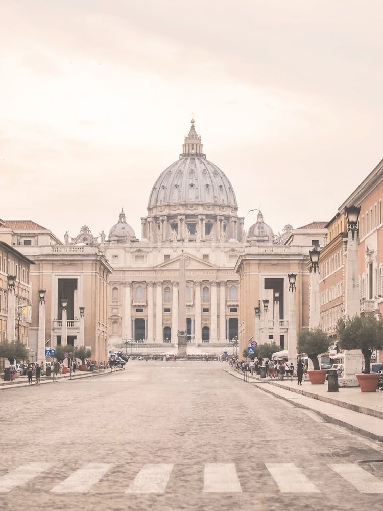 Rome, Italy I Iconic street view of the Vatican with St. Peter’s Basilica church dome and obelisk in a soft pastel aesthetic and symmetrical urban composition photography bathed in warm summer light