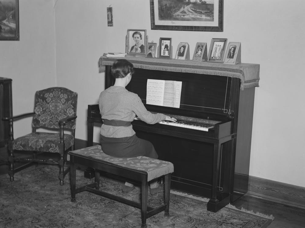 Lois Madsen Playing The Piano In The Home Of Her Father, Harry Madsen, Owner Operator Of Three Hundred And