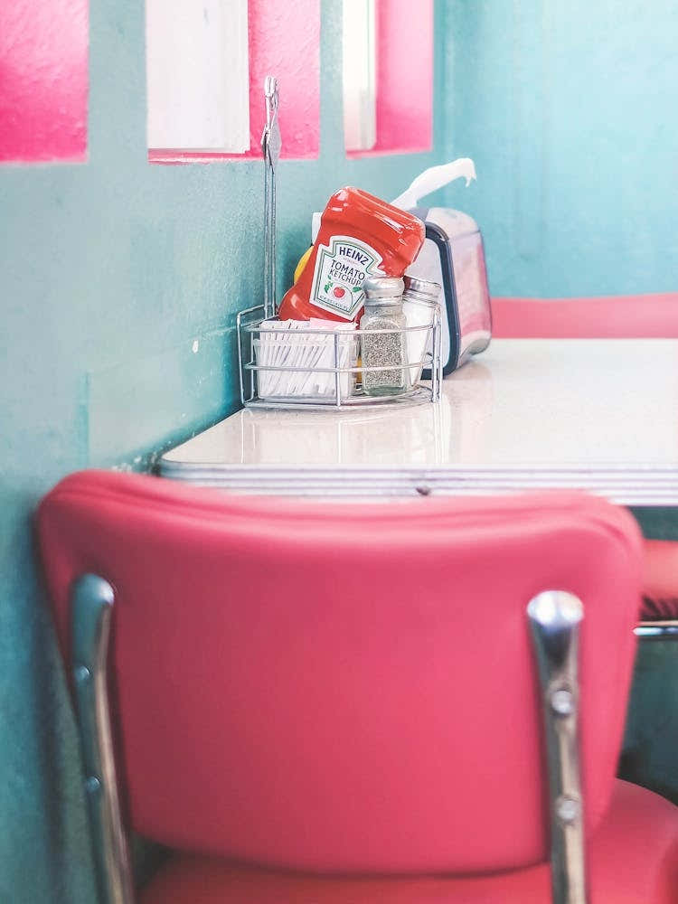 Route 66, USA I Interior of an American diner 50s retro vintage with pastel pink and blue aesthetic in the American countryside in Arizona or California captured as a lifestyle moment photography at the table
