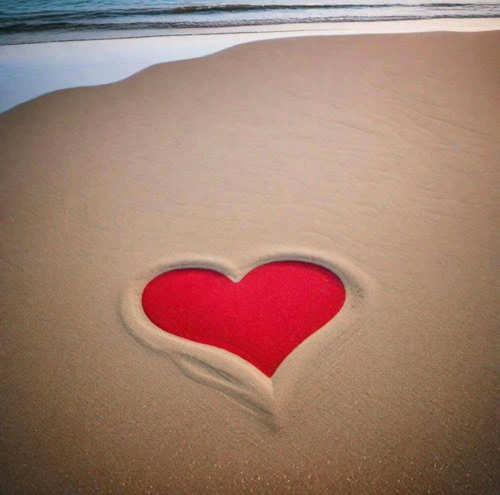 Red heart in the sand
