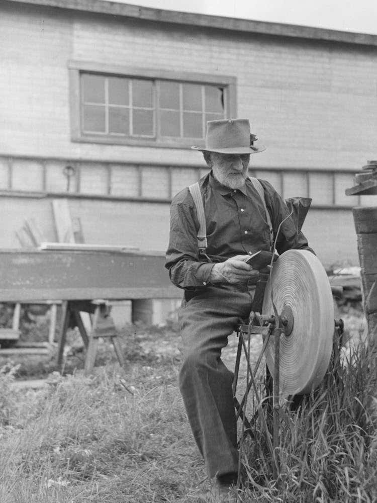 Old Resident Of Winton, Minnesota, Sharpening An Axe By Russell Lee