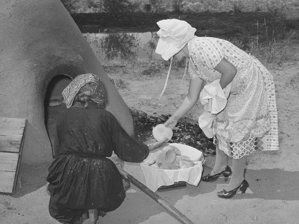 Wiping Ashes From Freshly Baked Bread Which Has Just Been Removed From Earthen Oven, Spanish American Farm