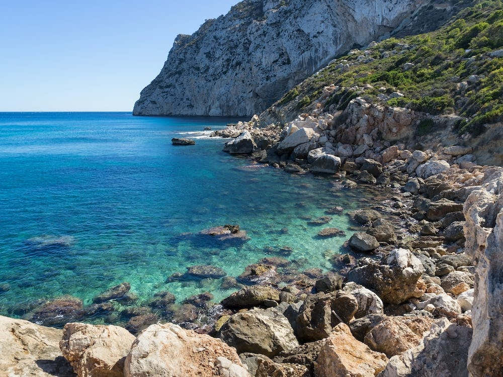 Turquoise sea water and rocky beach