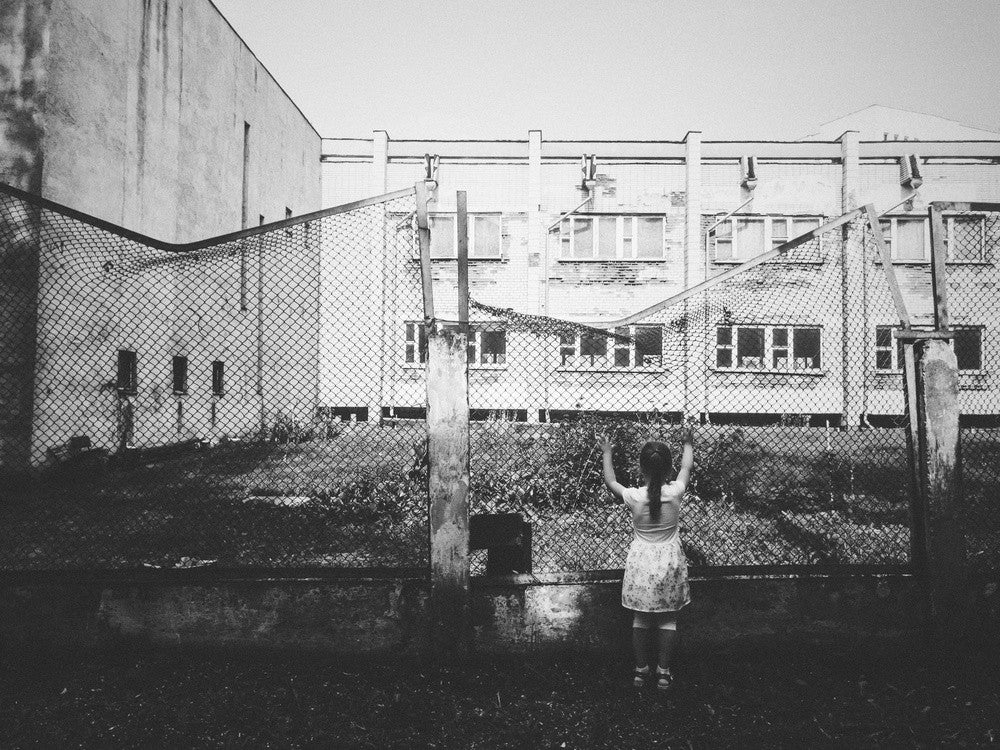 Young Girl Standing Before A Deteriorating Building