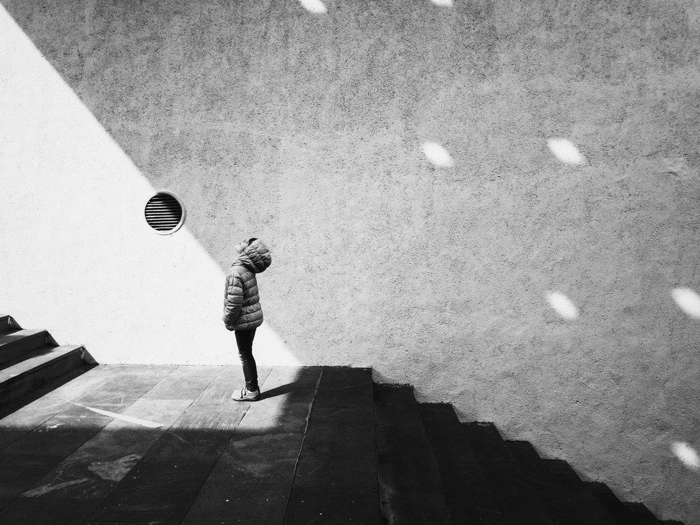 Einsamkeit in Schatten Eine Figur steht auf Treppen