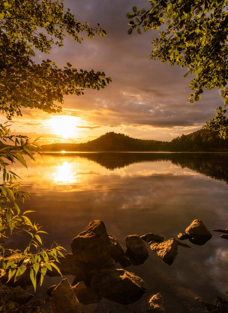 Sunset at a lake with a small mountain in the background
