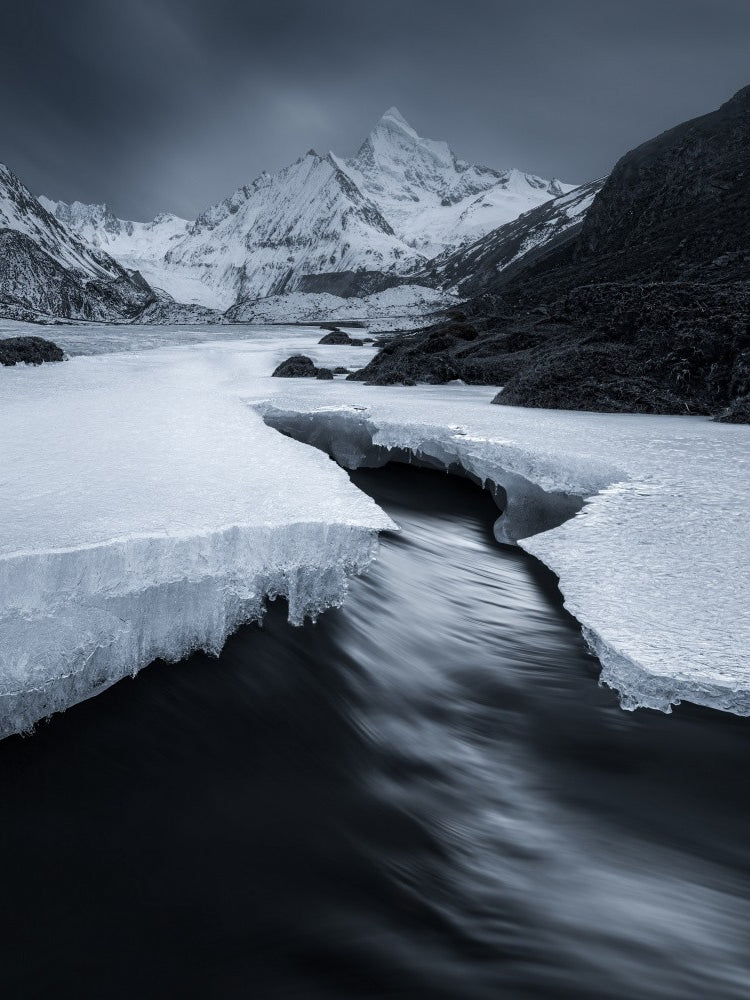 A stream under a snowy mountain