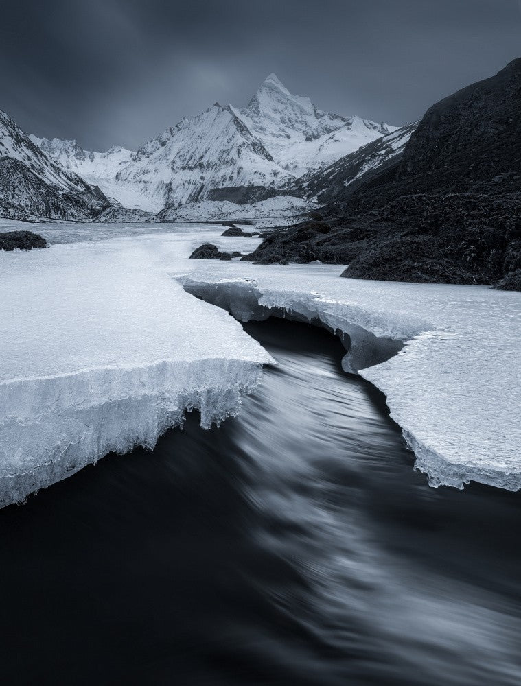 A stream under a snowy mountain