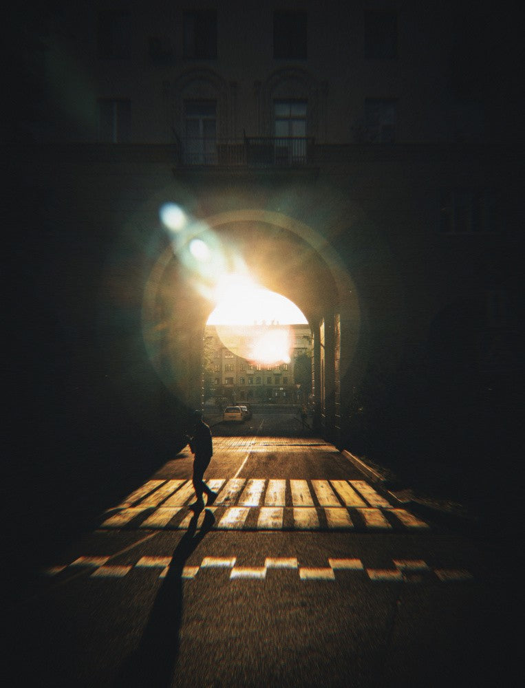 Sunlit Street Under An Archway