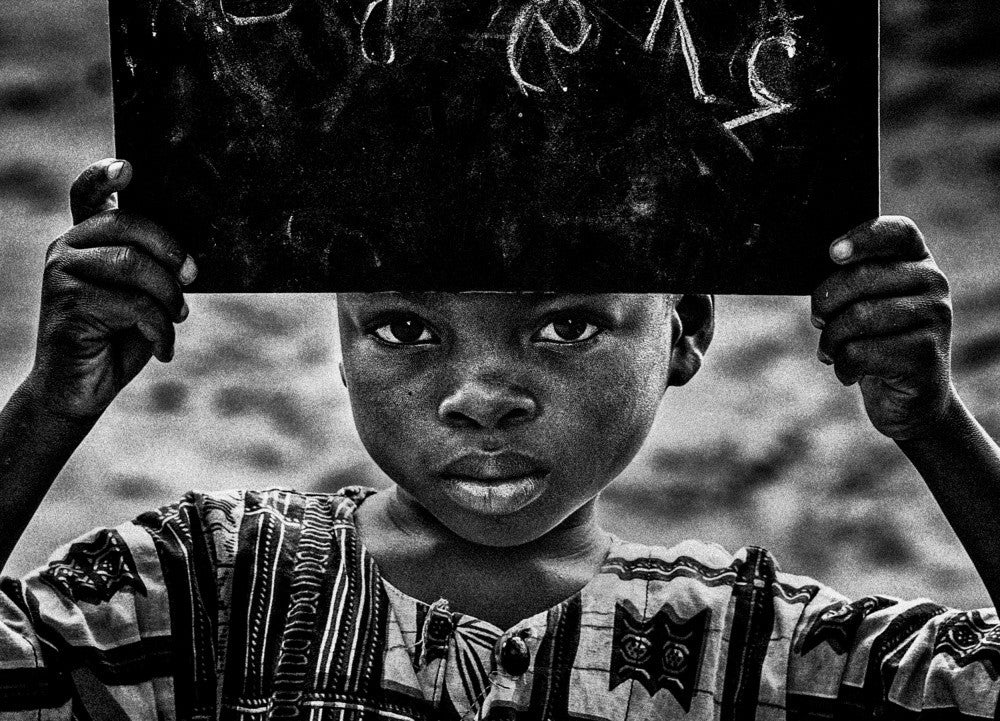 Junge aus Benin, der Zahlen auf der Tafel zeigt