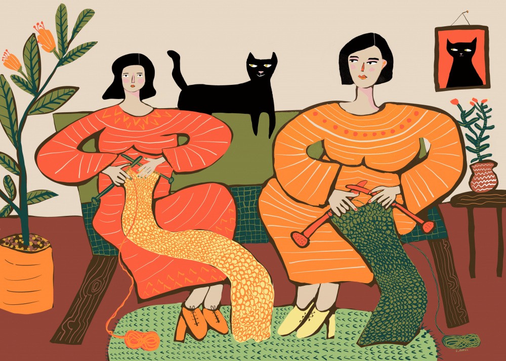 Femmes tricotant sur un canapé avec un chat noir