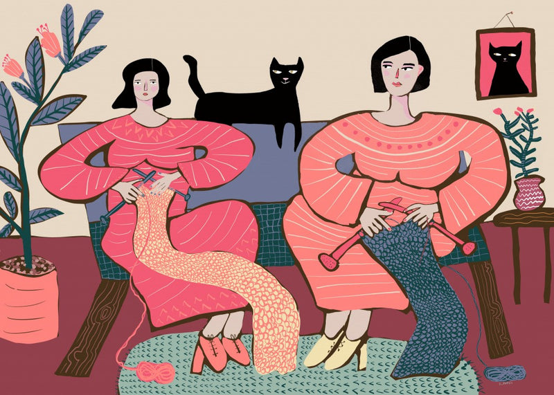 Femmes tricotant sur un canapé avec un chat noir