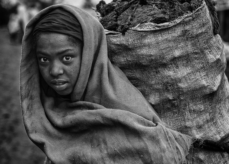 Fille éthiopienne transportant du fumier.
