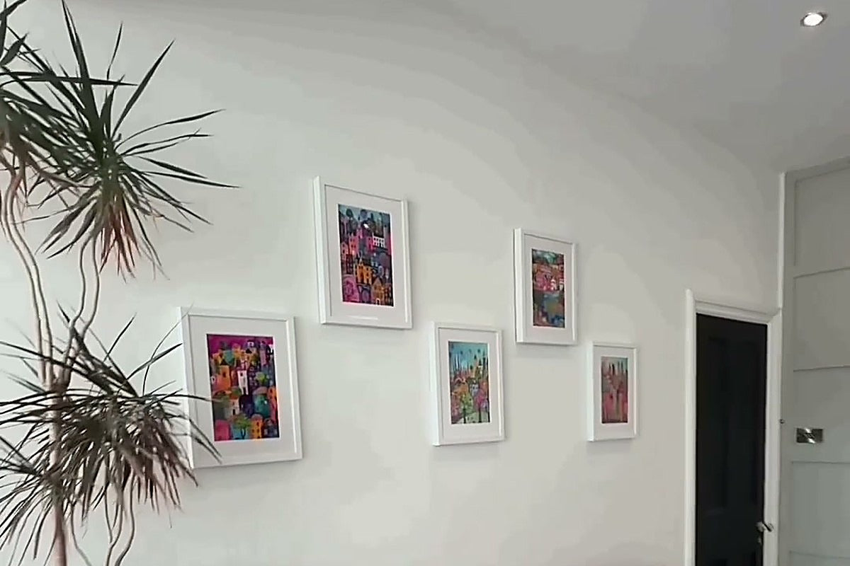 Living room gallery wall of five colourful kitsch cityscape prints