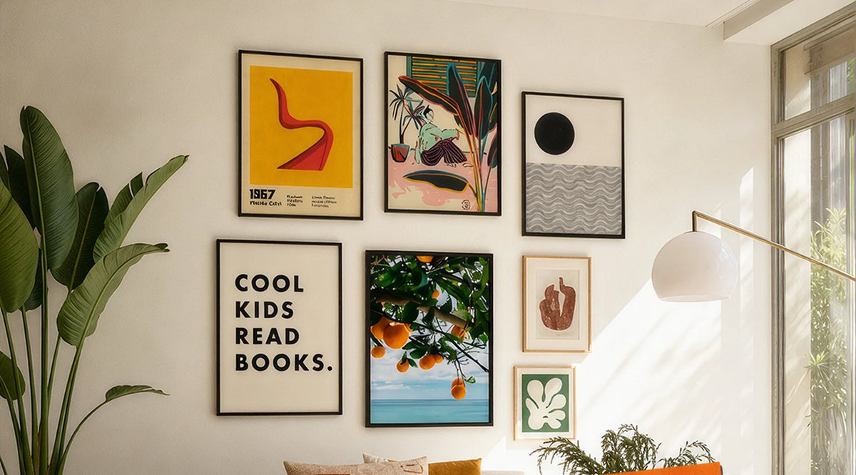 Gallery wall of framed prints above a boucle sofa beside a leather armchair