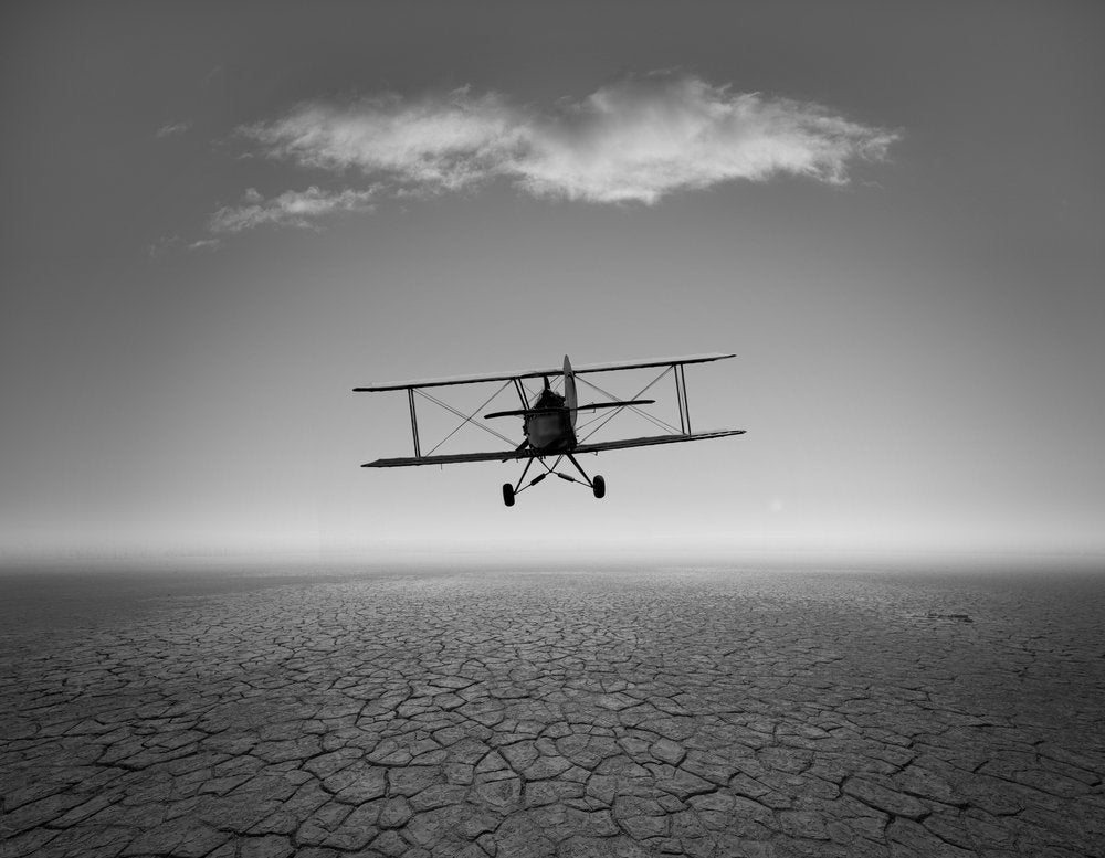 Biplane Over Cracked Earth