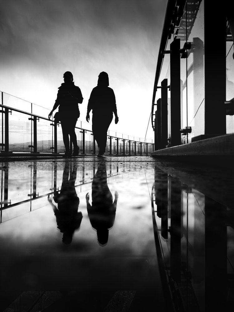 Silhouettes On Reflective Walk