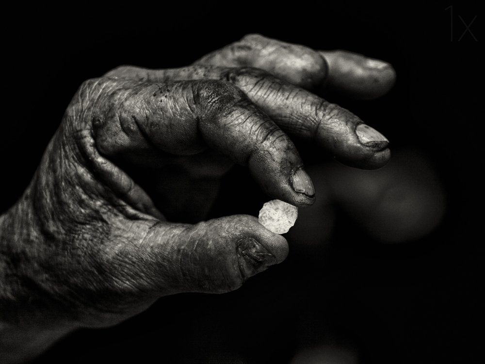 Old Hand Holding Stone