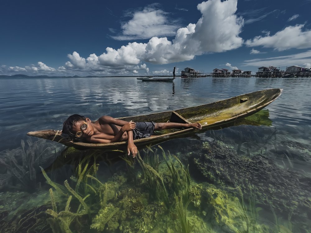 Boy Floating In Clear Water