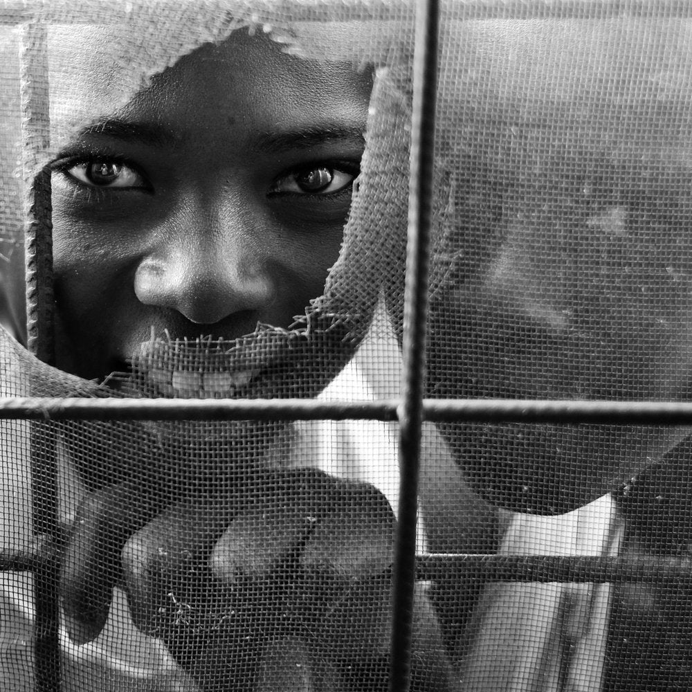 Curious Child Through Torn Mesh