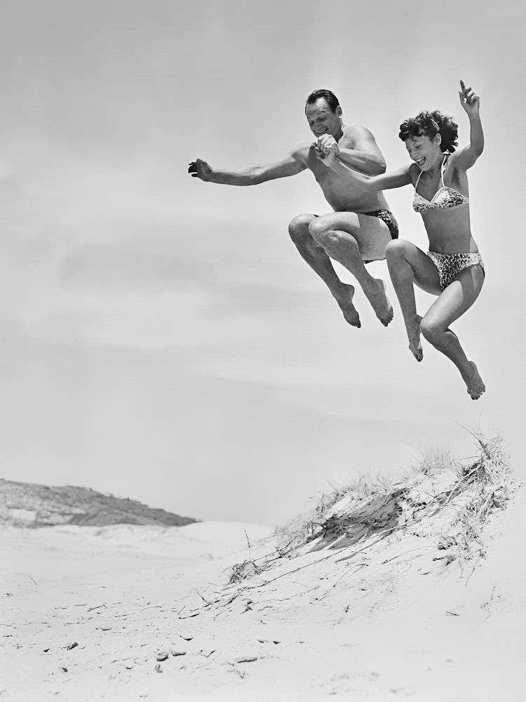 Paar springt im Sand, Vintage Schwarz-Weiß-Foto