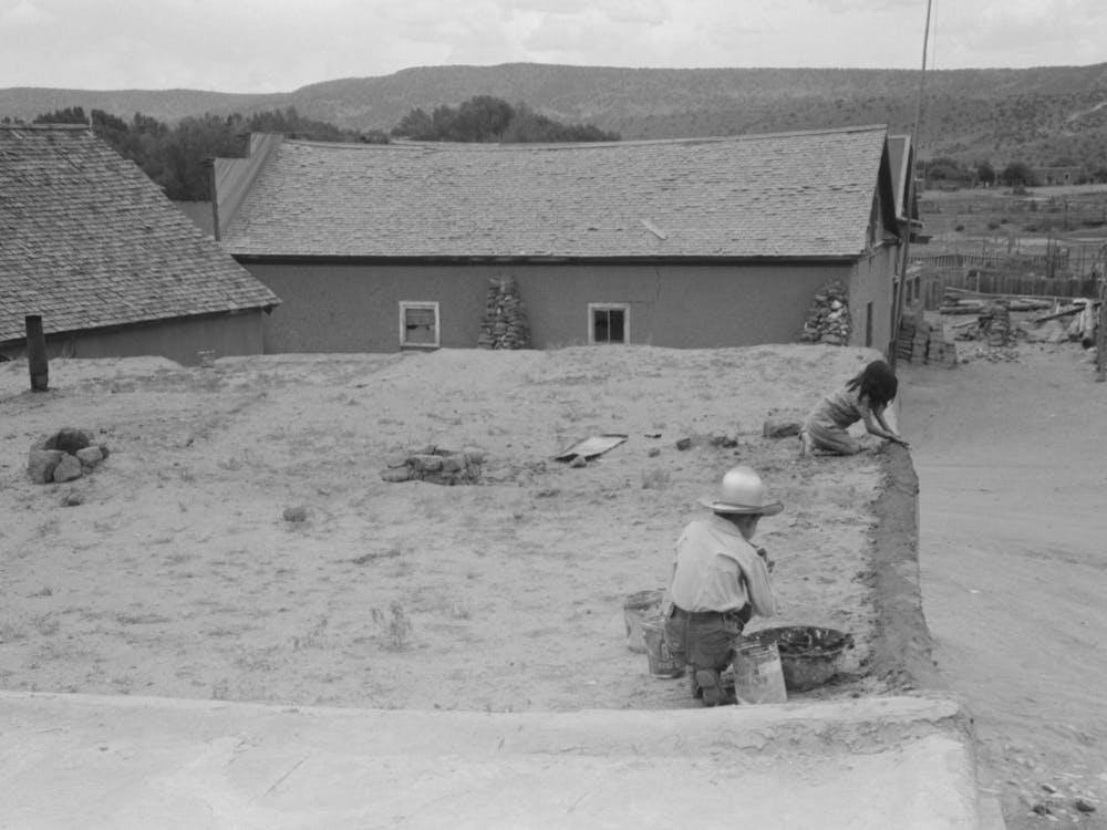 Spanish American Children Replastering Corner Of Roof Of Adobe House, Costilla, New Mexico By Russell Lee