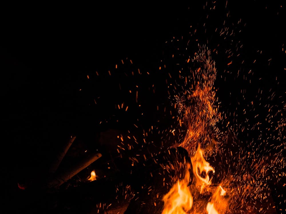 Sparks Bounce Off From A Bonfire At Night After A Log Thrown Into It 1