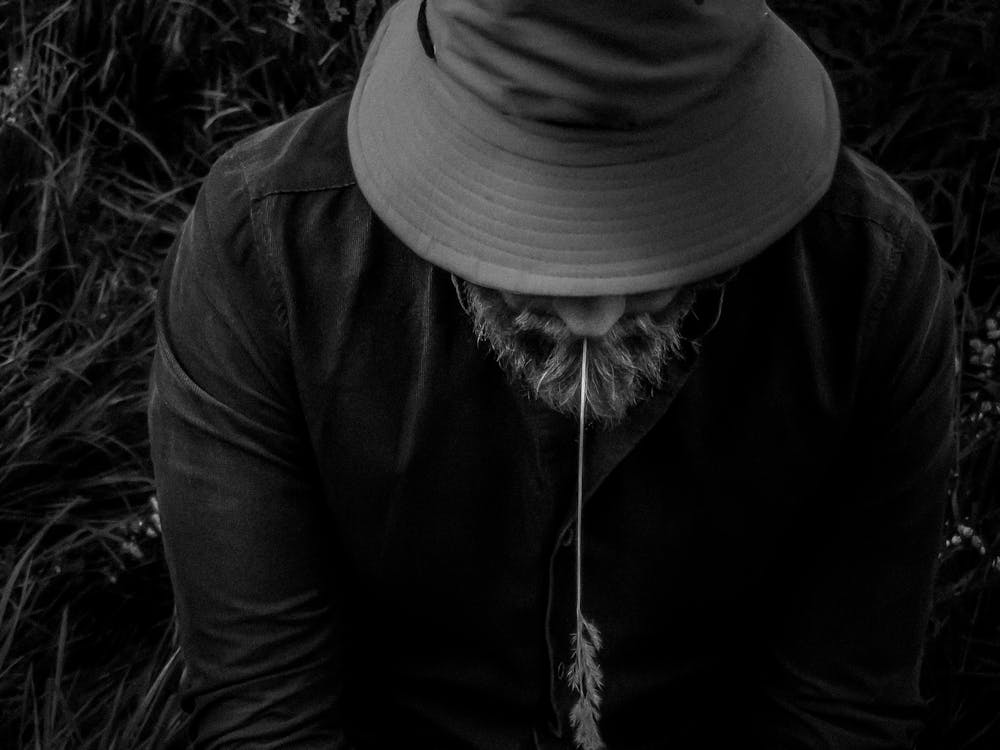 Black And White Photo Of A Man Wearing A Panama With A Spike.