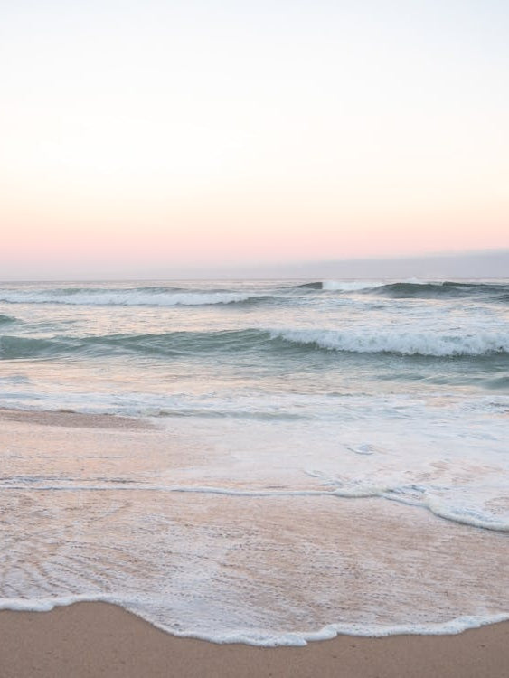 Pastel colors at sunrise. At the beach at Praia da Adraga in Portugal - pink and blue nature and travel photography by Christa Stroo