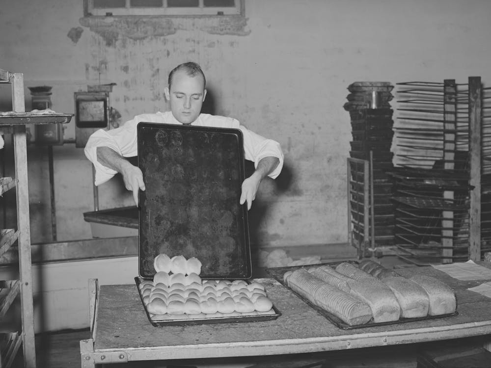 Removing Rolls From Tray At Bakery, San Angelo, Texas By Russell Lee