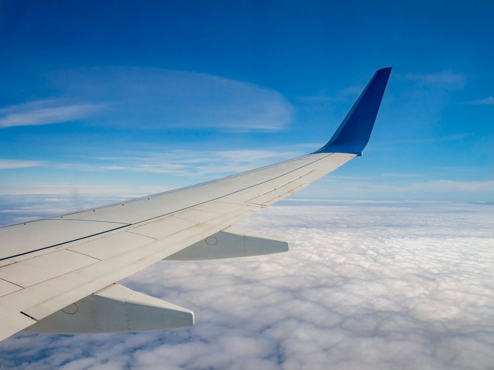 Airplane Wing On The Sky And Over Sea With Clouds