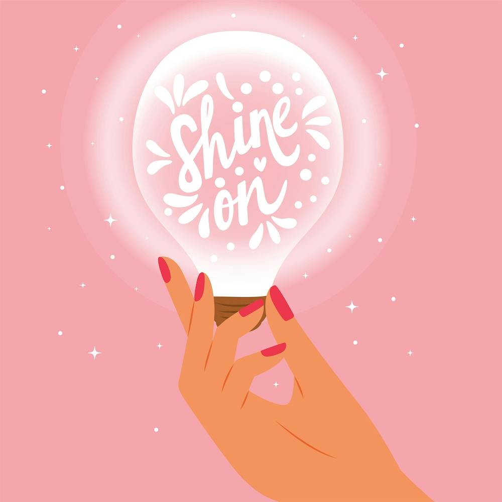 Shine On Hand Lettering With Hand Holding A Light Bulb On Pink Square