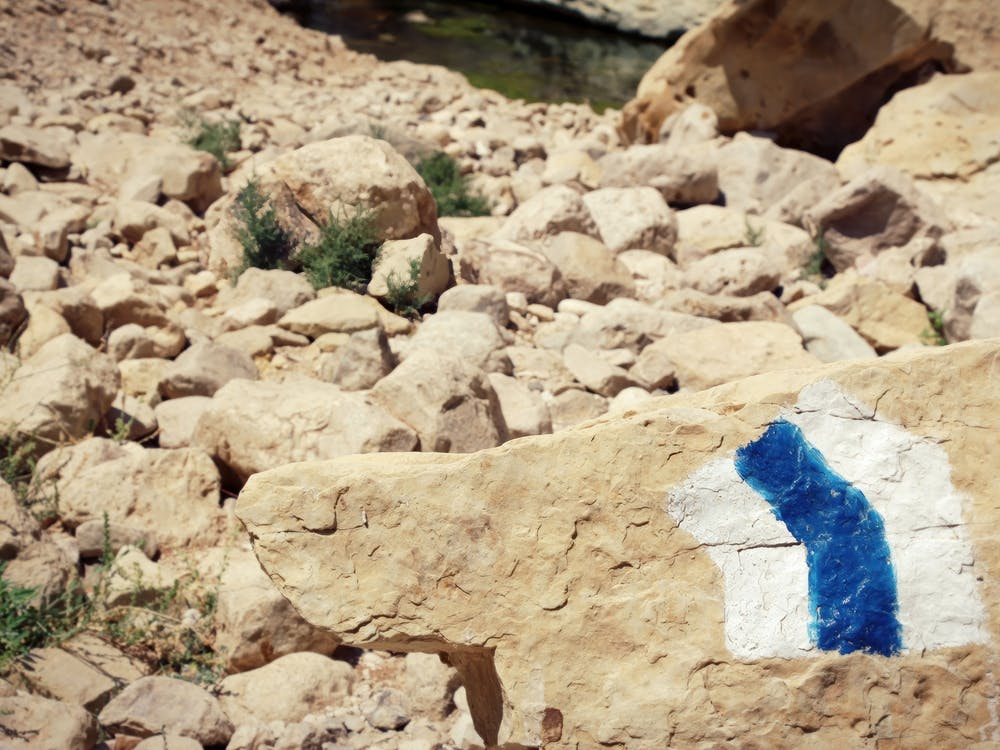 Hiking Trail Marker Painted On A Stone In Rocky Desert Area