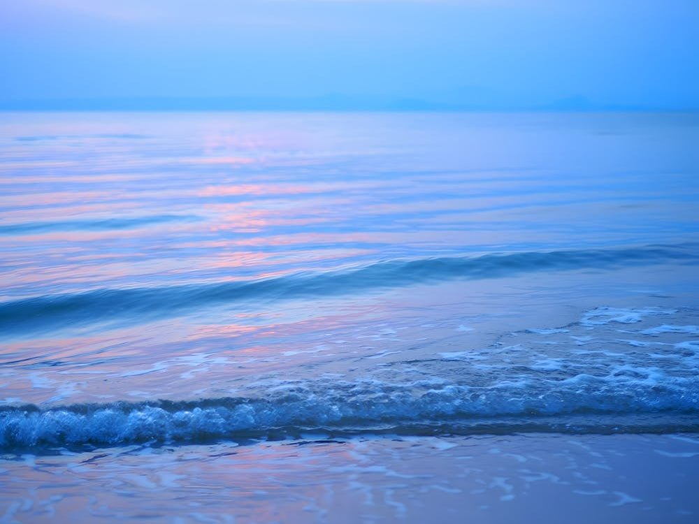 Calm Coastal Sunset: Serene Blue Tones Reflecting on the Water